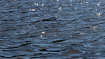 Close-up of dark blue rippling water with sunlight reflections
