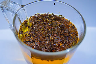 Close-up of loose leaf tea steeping in a glass cup