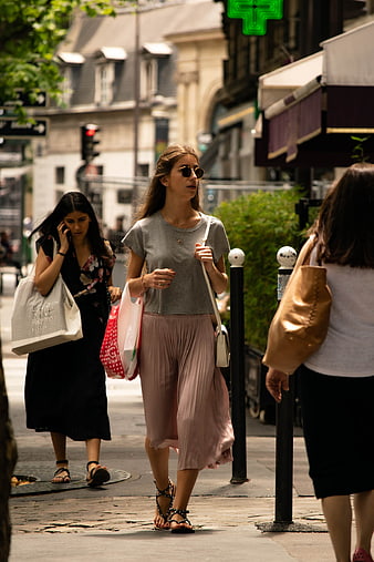 Woman walking on city street with shopping bags