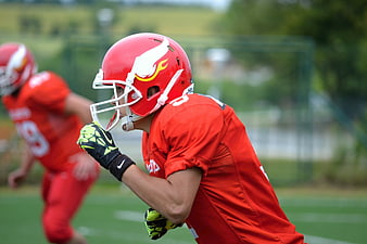 American football player in red uniform and helmet on field