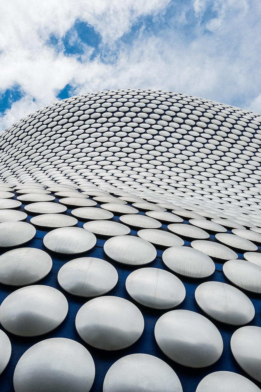 Modern silver dome architecture with circular patterns against blue sky