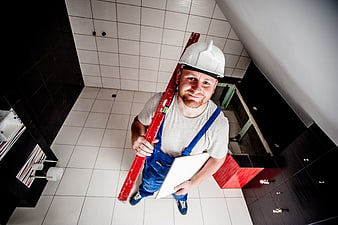 High angle view of smiling construction worker holding spirit level