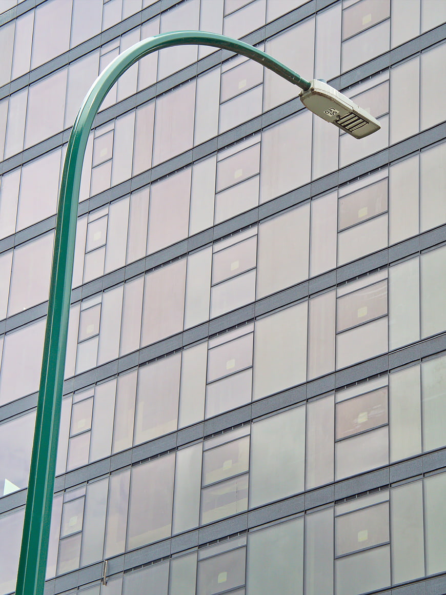 Green Street Lamp Against Modern Glass Office Building