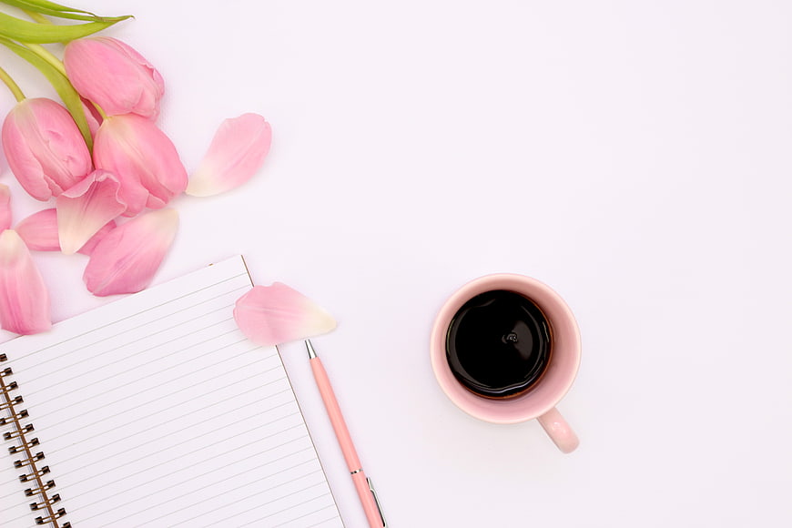 Pink Tulips, Coffee, and Notebook Flat Lay on White Background