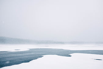 Serene Frozen Lake Landscape in Winter Snowstorm