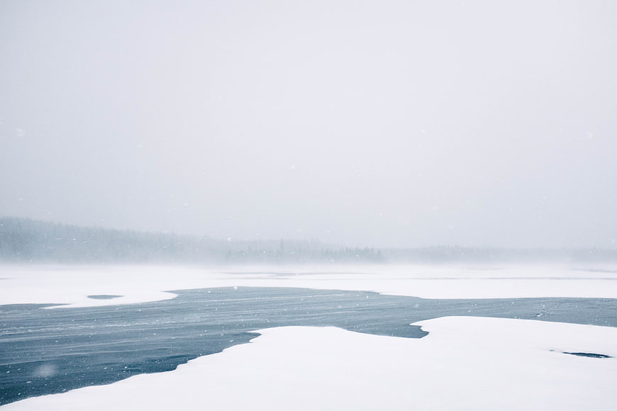 Serene Frozen Lake Landscape in Winter Snowstorm