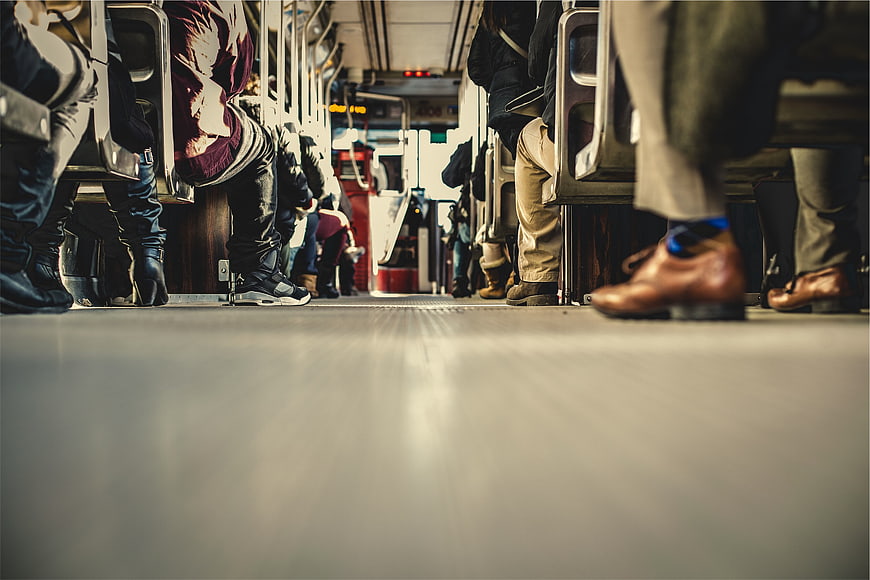 Low angle view of commuter legs and shoes on a bus aisle