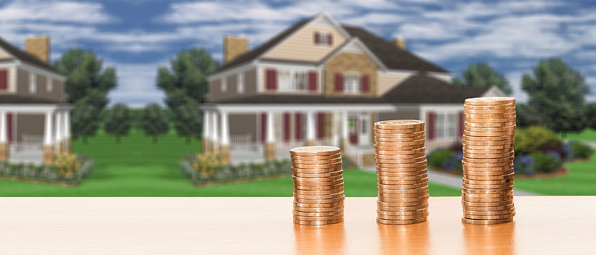 Real Estate Investment Concept With Stacked Coins And Suburban Homes