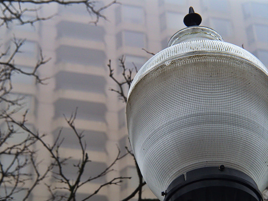 Close-up of vintage street lamp with bare branches