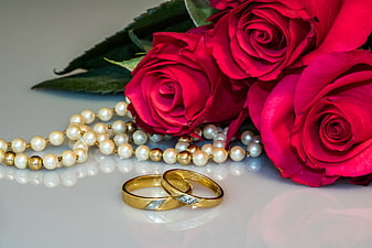 Gold wedding rings with red roses and pearls