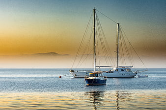 Sailboats Anchored in Calm Sea at Golden Sunset