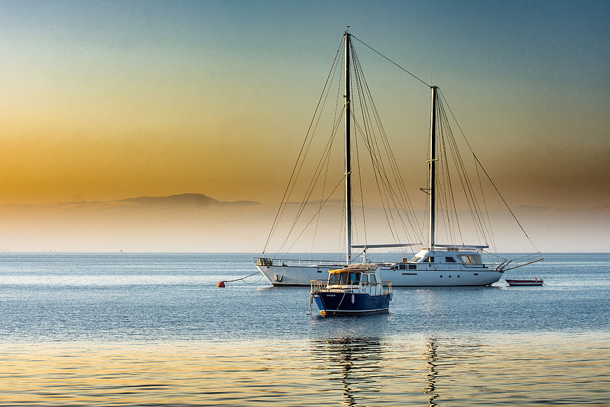 Sailboats Anchored in Calm Sea at Golden Sunset