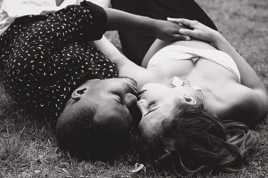 Romantic Black and White Photo of Couple Kissing on Grass