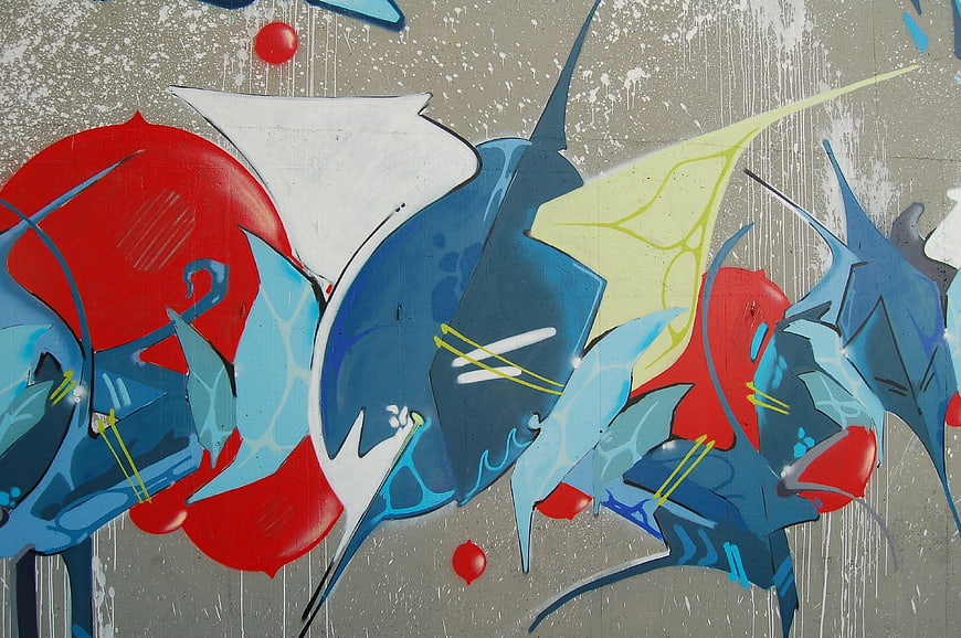 Abstract graffiti mural with blue and red shapes on concrete