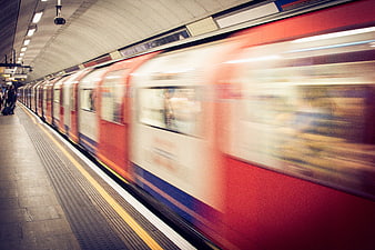 Motion Blur of Red and White Train Arriving at Underground Station