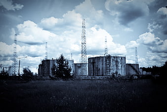 Abandoned industrial oil storage tanks under dramatic cloudy sky