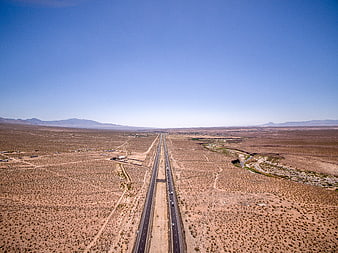 Aerial view of highway stretching through vast desert landscape