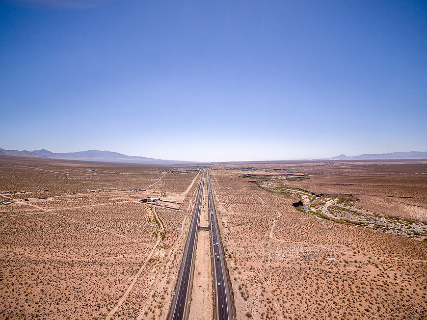 Aerial view of highway stretching through vast desert landscape