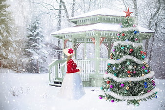 Woman in Red Coat Standing by Christmas Tree in Snowy Gazebo