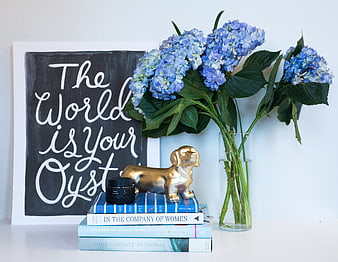 Blue hydrangeas and golden dog figurine on books