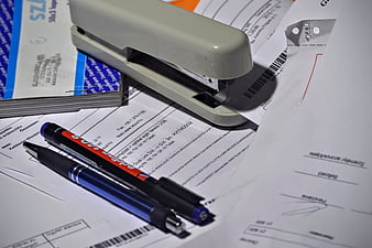 Office Stapler and Pens on Financial Documents