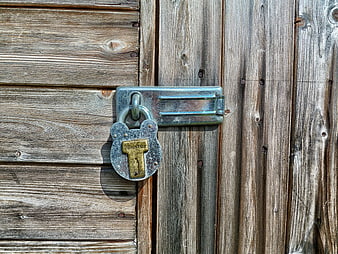 Rusty padlock on weathered wooden door