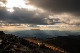 Dramatic Mountain Landscape with Sunbeams and Rocky Foreground