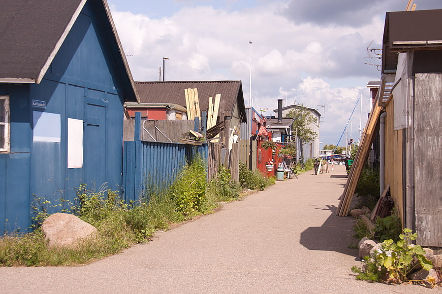 Narrow paved path between colorful wooden sheds in Copenhagen