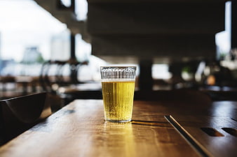 Glass of beer on wooden table in bar