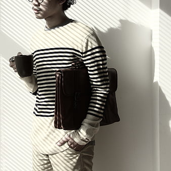 Man with Leather Messenger Bag and Coffee in Striped Light