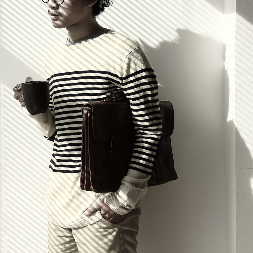 Man with Leather Messenger Bag and Coffee in Striped Light