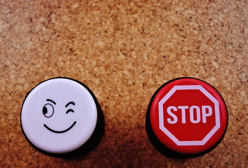 Winking smiley face and stop sign buttons on cork board