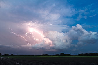Dramatic Lightning Strike Over Dark Agricultural Field at Dusk