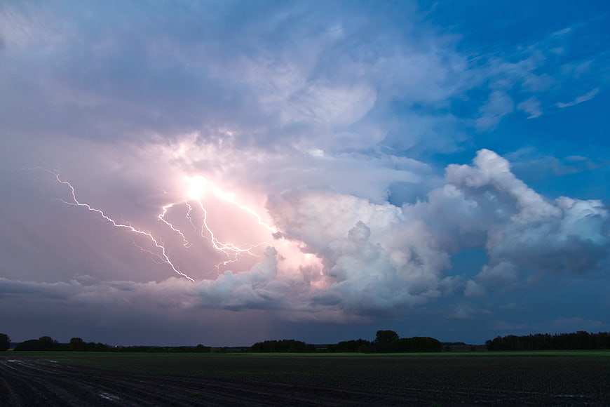 Dramatic Lightning Strike Over Dark Agricultural Field at Dusk