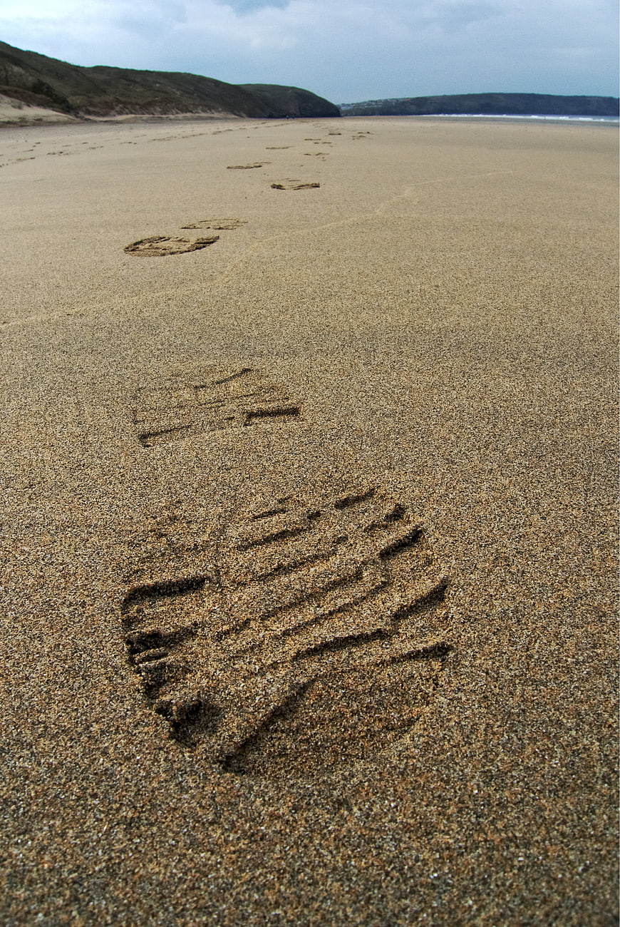 Boot Prints in Sand on Beach Leading to Dunes