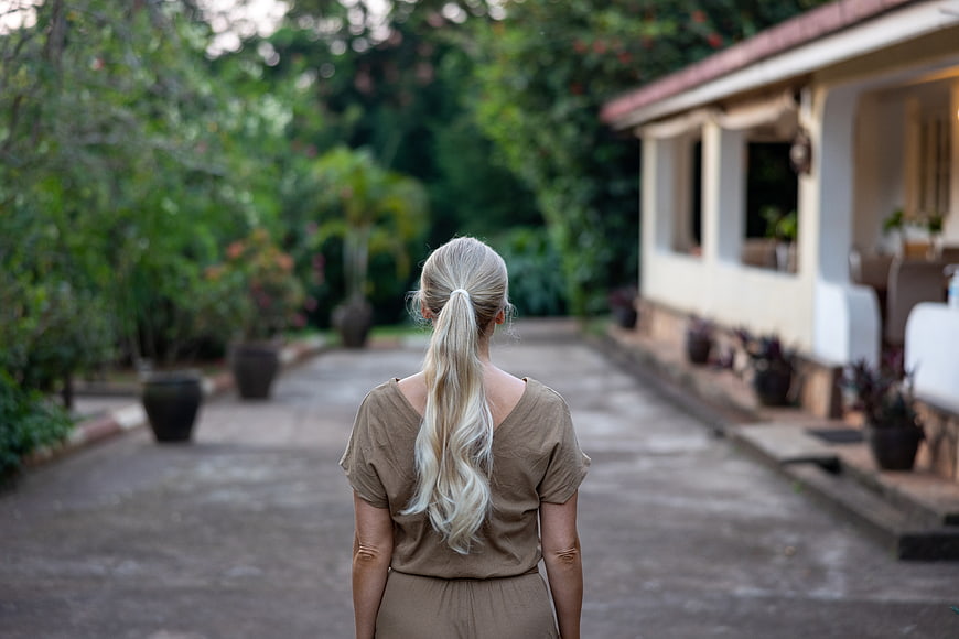 Blonde Woman Walking Away on Garden Path