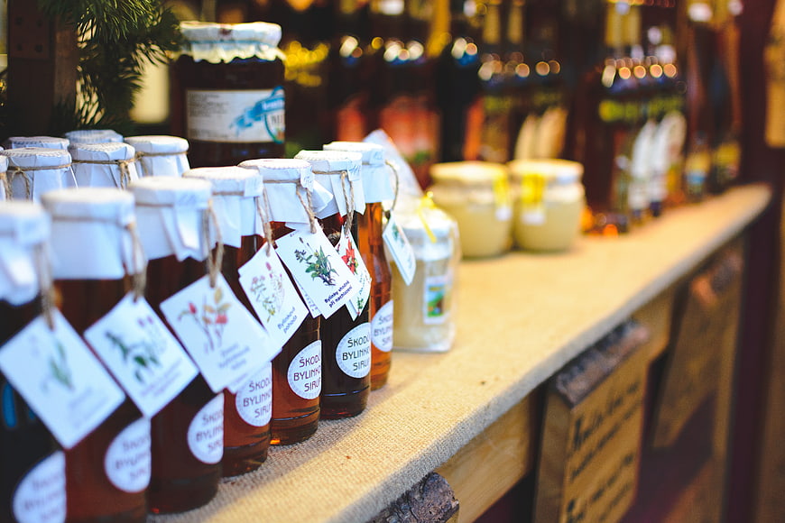 Natural herbal syrups on wooden shelf at Christmas market