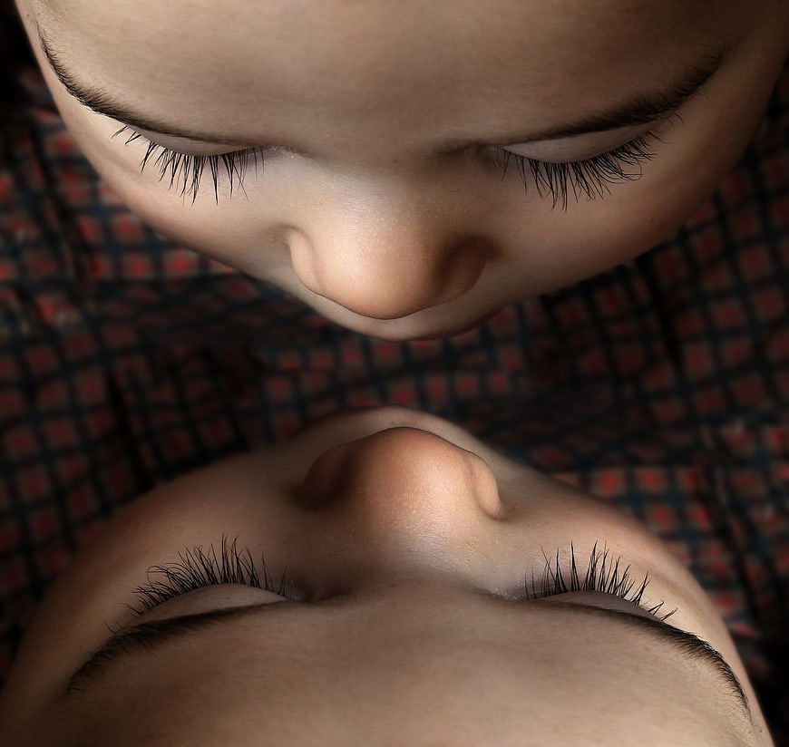 Close-up of two sleeping babies with closed eyes and long eyelashes