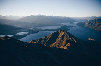 Sunlit Mountain Peak Overlooking Lake and Valley