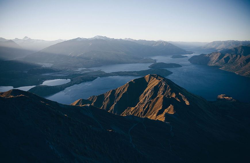 Sunlit Mountain Peak Overlooking Lake and Valley
