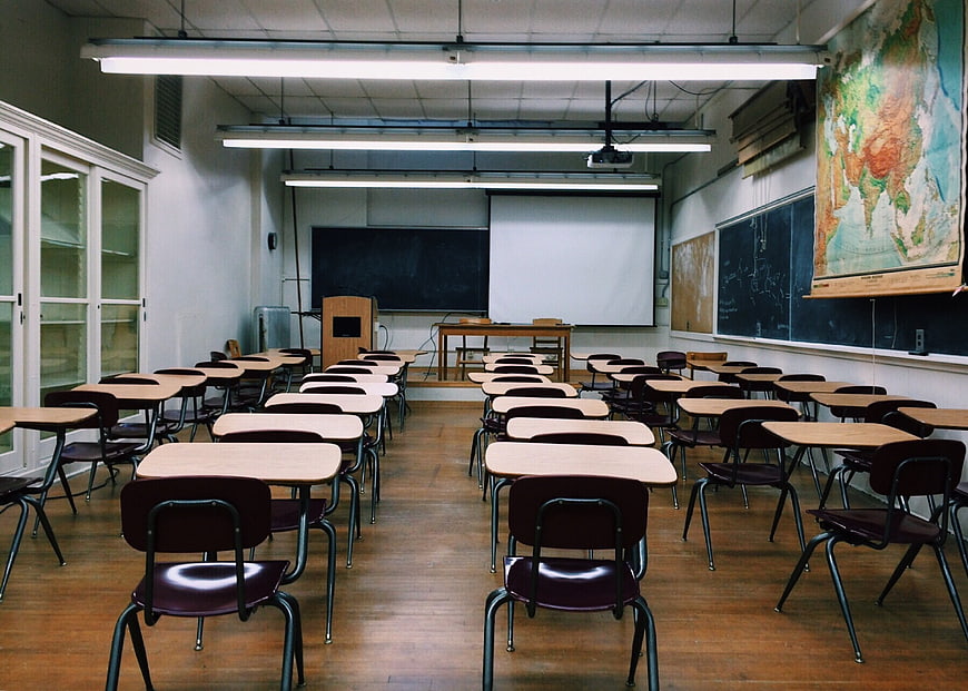 Empty Classroom with Desks, Blackboard, and World Map