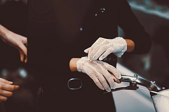 Close-up of hands in white mesh gloves on bicycle handlebars