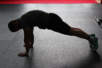Man doing plank exercise in gym with resistance band