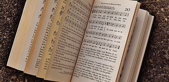 Open German Hymnal with Sheet Music on Gravel