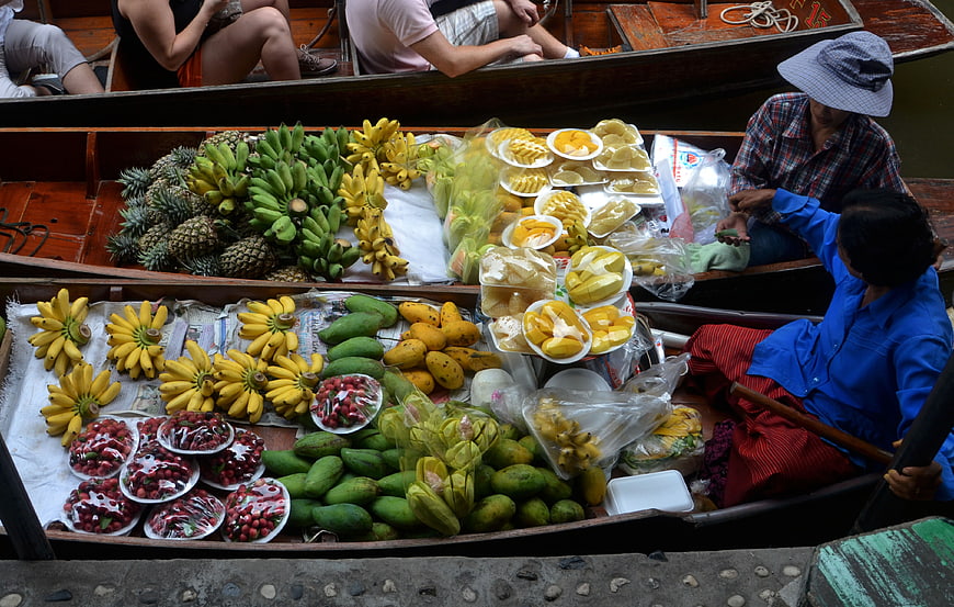 Fresh tropical fruits sold from wooden boats at a floating market