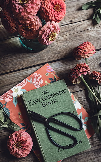 Vintage gardening book with zinnias and shears on rustic wood