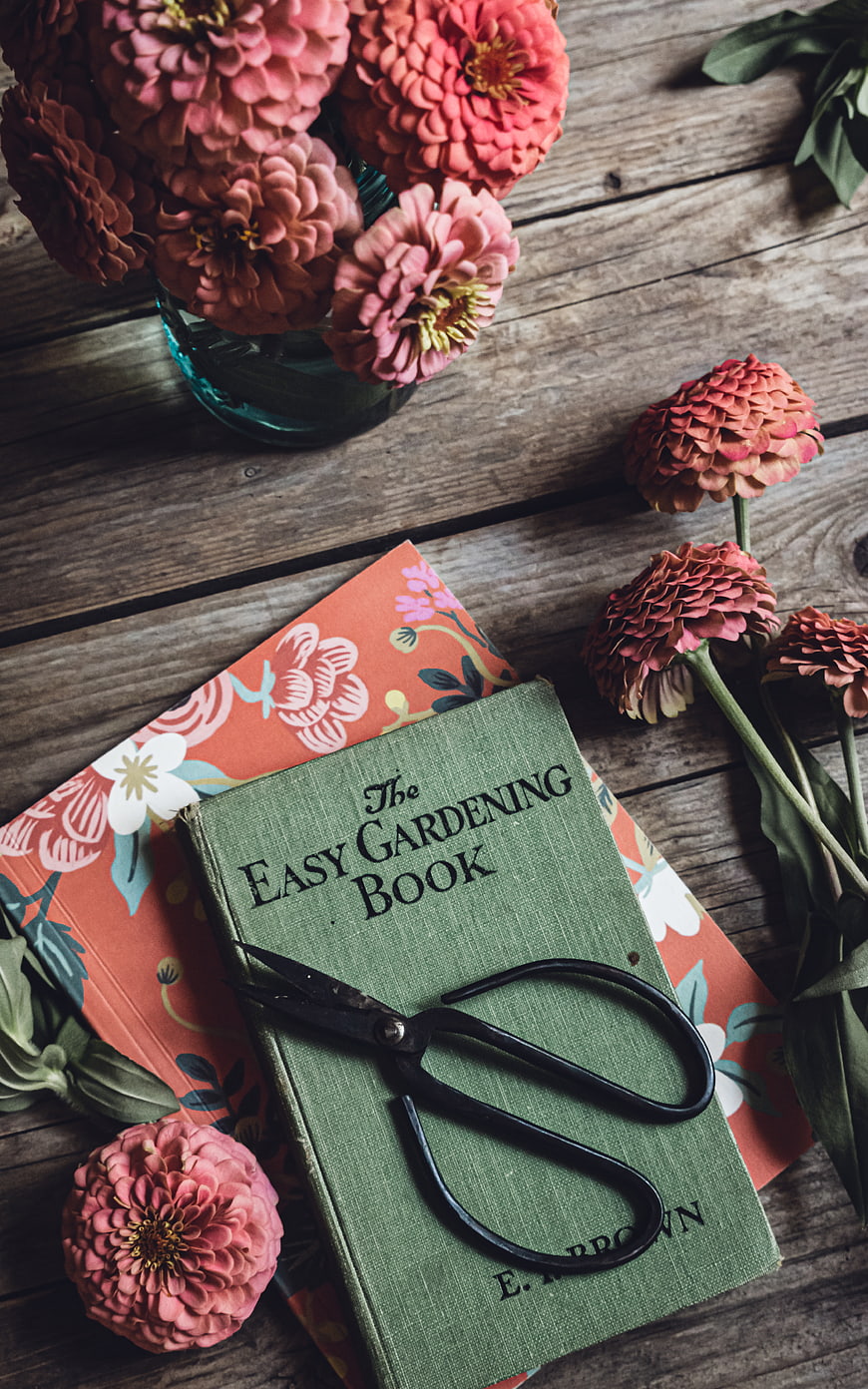 Vintage gardening book with zinnias and shears on rustic wood