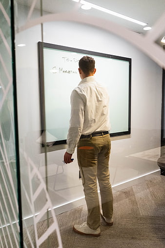 Businessman writing marketing to-do list on whiteboard