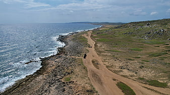 Aerial View of Coastal Dirt Road with Off-Road Vehicles