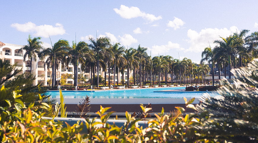 Tropical Resort Pool with Palm Trees and Hotel Building